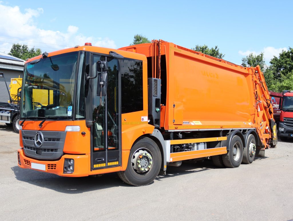Front nearside of a Mercedes Econic 2630L fitted with MOL Pusher 4000 bood MOL MAXLIFT CB011 Trade Rear End Loader